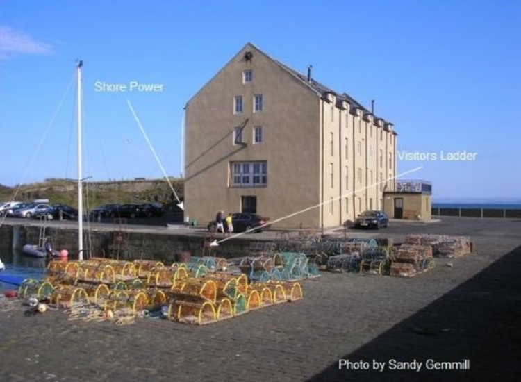 Elie Harbour. Former granary showing visitors berth and supplies.
